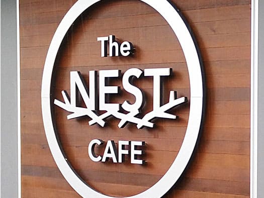Sign for The Nest Cafe with wooden background and 3D lettering.