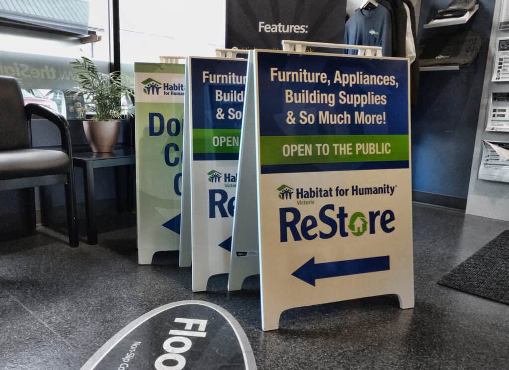 Outdoor A-frame sign promoting Habitat for Humanity ReStore in Victoria.