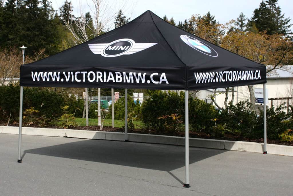 Custom vehicle wraps tent with Victoria BMW branding and website.