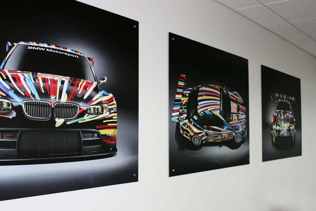 BMW Motorsport car with vibrant, custom wrap displayed on wall.