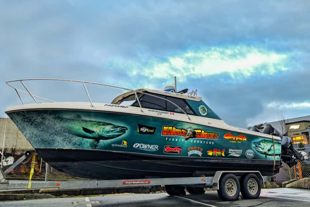 Custom boat wrap featuring colorful graphics and sponsor logos on a motorboat.